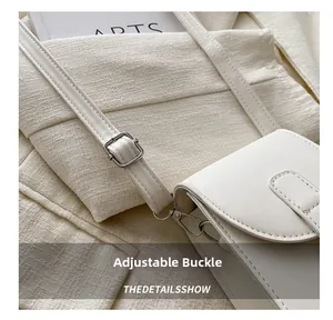 Detail view of the silver metal adjustment buckle on a white leather shoulder bag strap