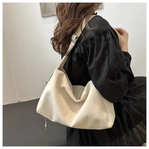 Detailed view of the large off-white nylon hobo tote bag worn as a shoulder bag