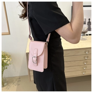 Detail of pink faux leather phone bag with silver buckle and accordion side fold design