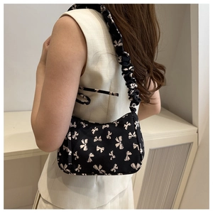 Detail of floral shoulder bag with white bow pattern and ruffled drawstring strap