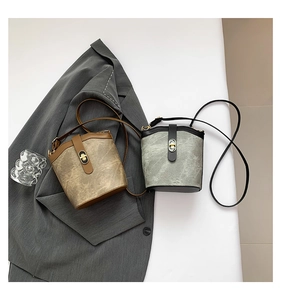 Flat lay of vintage mini bucket bags in brown and grey leather with gold buckles