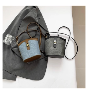 Close-up of retro bucket bags in denim and grey suede with metallic twist-locks