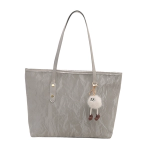 Silver metallic tote bag with bamboo texture and cute plush charm on white background