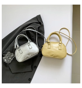 Detailed view of mini bowling bags in silver mirror and pale yellow vegan leather