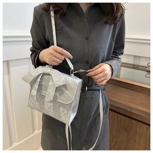 Mini sac argenté métallisé avec grand nœud porté comme une élégante bandoulière