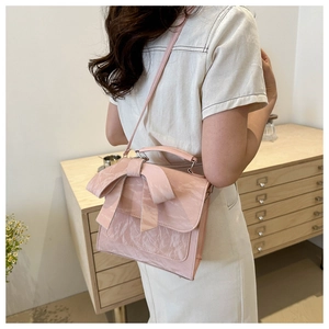 Mannequin portant un sac bandoulière plissé avec un nœud rose et une poignée chic