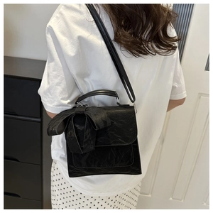 Sac à bandoulière noir élégant avec grand nœud et finition en cuir texturé pour femme