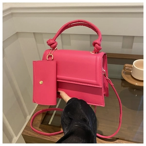 Close-up of rose pink square handbag with knotted handle and matching mini pouch