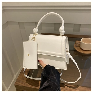 Detailed view of white minimalist handbag set with knot handle and mini pouch charm