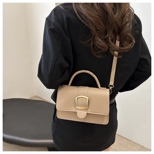Vue détaillée du sac bandoulière kaki avec boucle dorée et bandoulière réglable