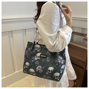 Schicke schwarze Totebag mit Totenkopf-Blumenmuster und silberner Kette am Model