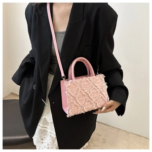 Detailed view of pink quilted denim handbag with frayed edges and top handle strap