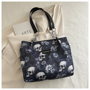 Detail of skull print tote bag with silver chain strap and fashion label on fabric