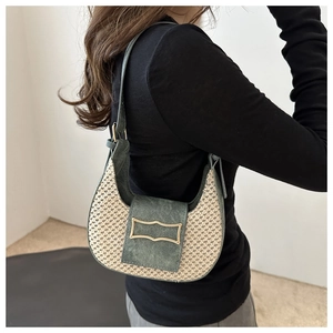 Retro beige straw hobo bag with green leather trim and golden buckle on model