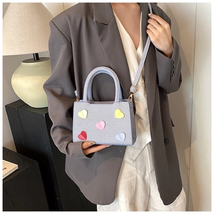 Chic light blue woven handbag with colorful heart patches and detachable shoulder strap