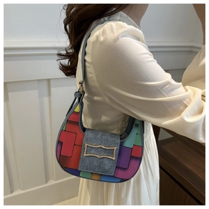 Detail of colorful geometric patchwork crescent bag with elegant gold metal buckle hardware