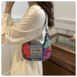 Detail of colorful geometric pattern crescent bag with a gold wavy metal buckle