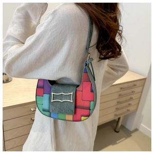 Colorful geometric patchwork crescent hobo bag with denim strap on woman shoulder
