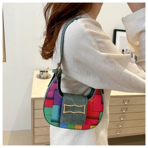 Detail of colorful patchwork woven crescent bag with vintage gold buckle and green strap