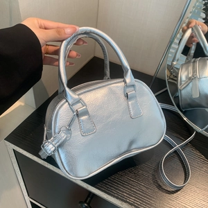 Minimalist silver pleated leather handbag with metallic texture and crossbody strap