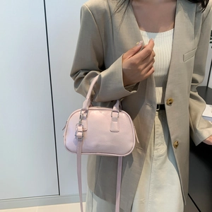 Chic pink PU leather top handle crossbody bag shown on a model in a modern room