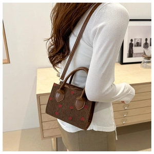 Detail of brown corduroy tote bag with strawberry embroidery and leather handles