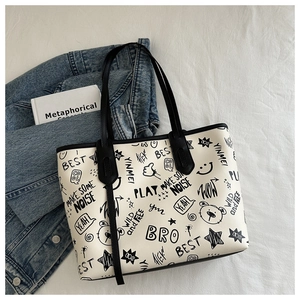 Dettaglio della borsa tote in PU bianca con stampa graffiti nera e spalline lunghe