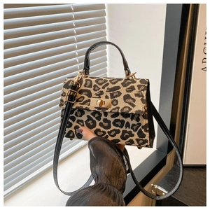 Detail of leopard print fabric texture and gold twist lock on women's crossbody bag