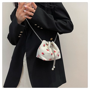 Detail of corduroy strawberry bucket bag with pearl drawstring and silver chain strap