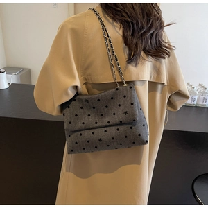 Detail of grey wool tote with polka dots and bow embroidery on a chain strap
