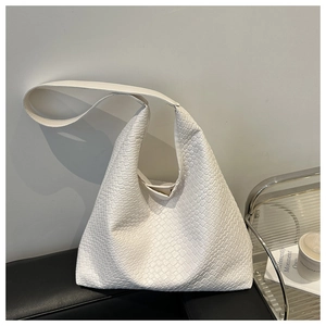 Detail of white woven texture and soft hobo style shoulder bag in minimalist modern home setting