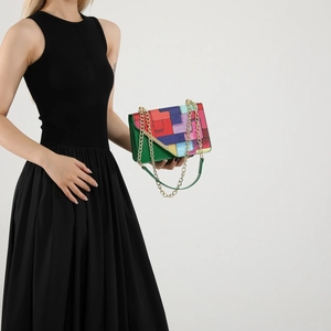Colorful geometric patchwork shoulder bag with gold chain strap on female model