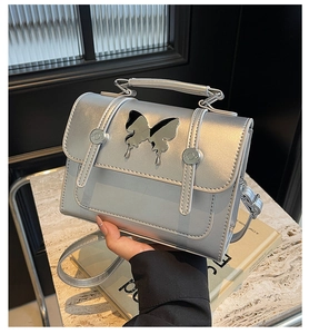 Détail du sac argenté métallisé avec boucle papillon et bandoulière réglable