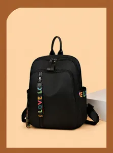 Detail eines schwarzen Nylon-Rucksacks mit bunten LOVE-Webbändern und Reißverschlüssen