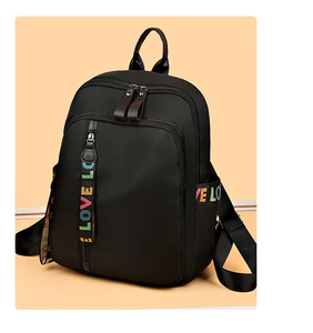 Detail eines schwarzen Nylon-Rucksacks mit bunten LOVE-Buchstabenriemen und Tasche