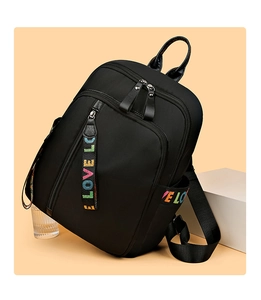 Detail eines wasserdichten Nylon-Rucksacks mit bunten LOVE-Anhängern und Seitentaschen