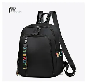 Detailansicht der Seite eines schwarzen Nylonrucksacks mit bunten LOVE-Webgurtbändern