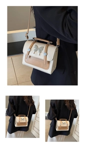 Détail d'un sac bandoulière vintage avec boucle papillon et coutures contrastées