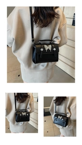 Détail d'un petit sac carré noir vintage avec boucle papillon argentée et bandoulière