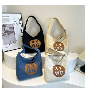Detail of four colorful canvas tote bags with leather logo patch in a lifestyle setting