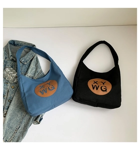 Detail of hobo canvas bags with leather logo patch in misty blue and black colors