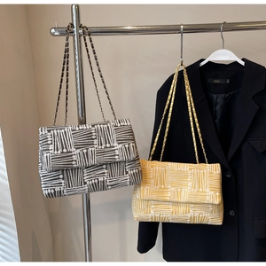 Detail of woven chain shoulder bags with embossed texture in dark grey and bright yellow