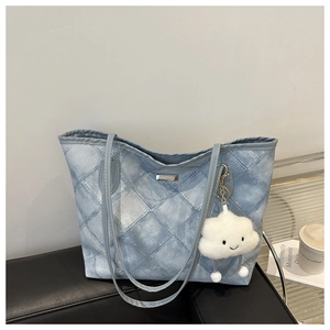 Détail du sac cabas en jean matelassé avec charme nuage peluche et plaque métal