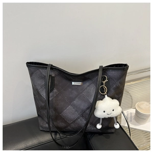 Détail du sac cabas matelassé gris avec logo métallique et pendentif nuage en peluche