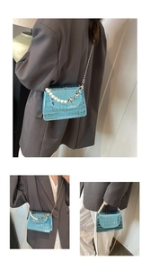 Détail du mini sac bleu à motif crocodile avec anse en perles et chaîne argentée