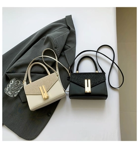 Detail of elegant sequined handbags in cream and black with gold metal locks