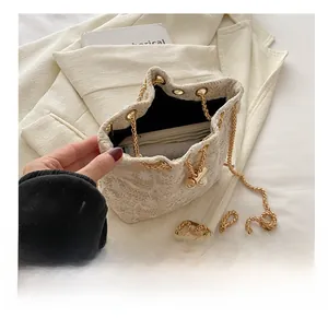 Detail view of white lace embroidered bucket bag showing interior capacity and phone