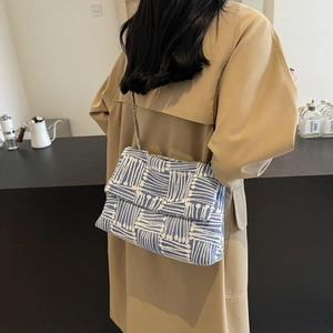 Retro blue and white geometric woven shoulder bag with silver metal chain strap on model