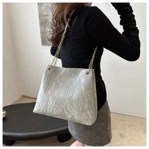 Vue détaillée d'un sac cabas gris avec fini plissé brillant et lettrage fashion embossé