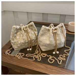 Straw bucket bag with floral embroidery and gold chain strap in light brown and cream